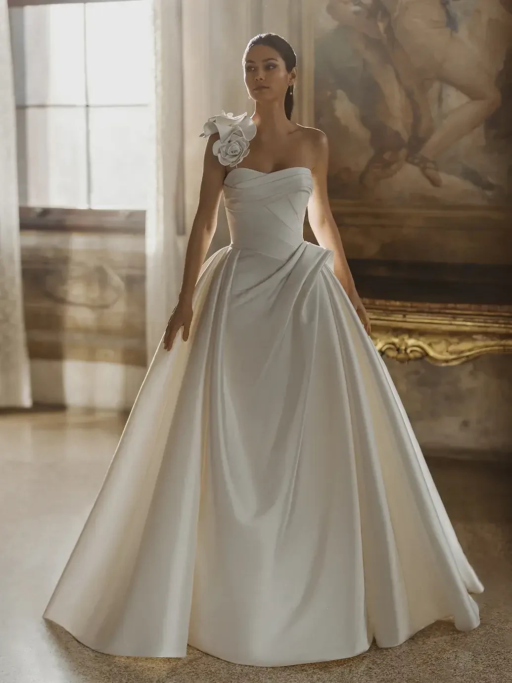 model is wearing a strapless mikado ball gown wedding dress