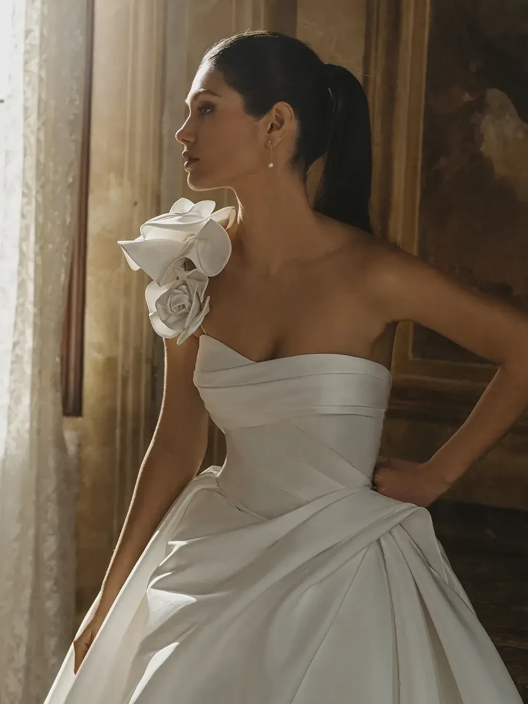 model is wearing a strapless mikado ball gown wedding dress