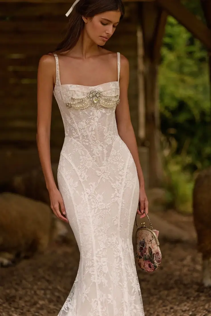 model is wearing a sleeveless lace wedding gown