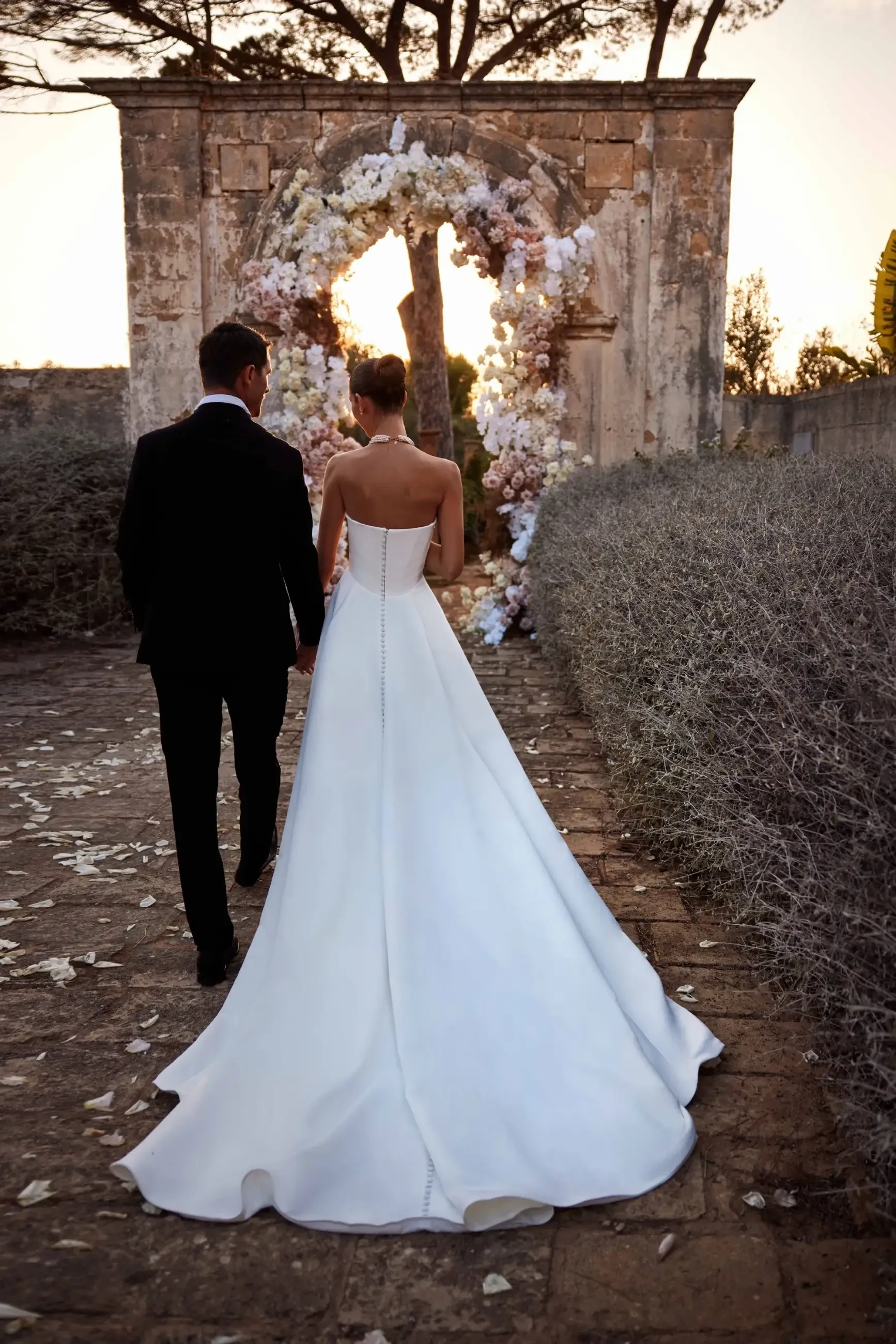 model is wearing a strapless satin bridal gown with a slit 